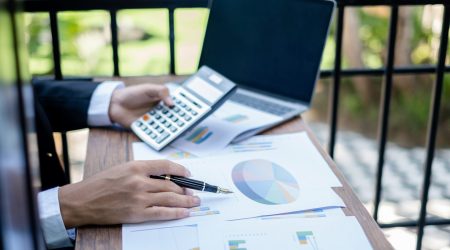 Young businessman financial market analyst sits at their desks and calculate financial graphs showing the results of their investments planning the process of successful business growth.